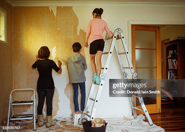 mixed race mother and children stripping wallpaper in living room - palmerston north nz bildbanksfoton och bilder