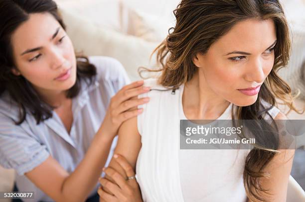 hispanic woman comforting angry friend - sad girlfriend stock pictures, royalty-free photos & images