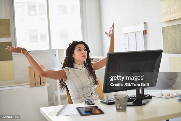 mixed race businesswoman frustrated at computer at desk in office - banging your head against the wall stock pictures, royalty-free photos & images