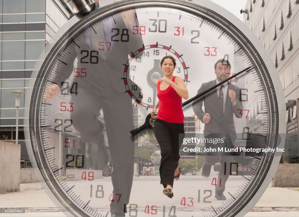 Double exposure of stopwatch and business people running outdoors