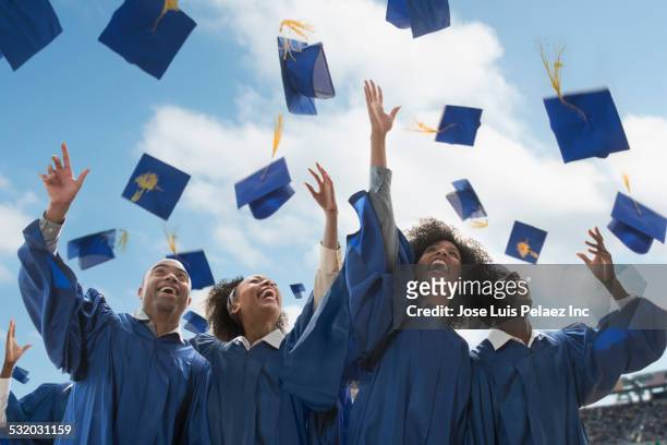 students throwing caps at graduation - graduation celebration stock pictures, royalty-free photos & images