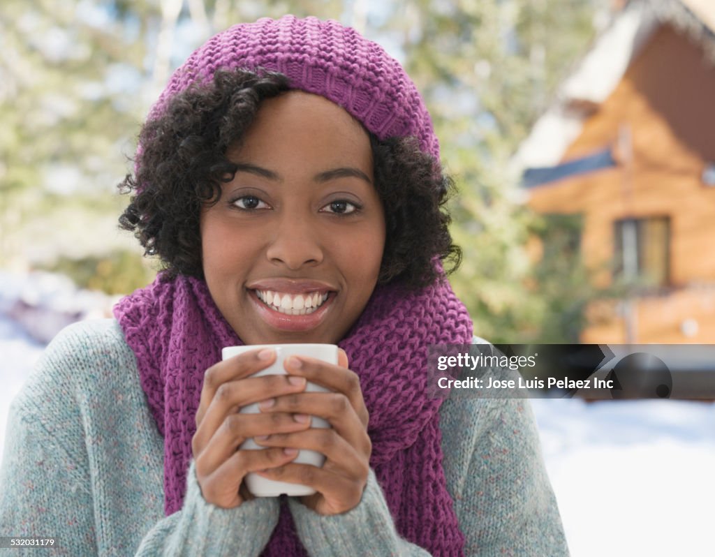 African American woman drinking cup of coffee in winter