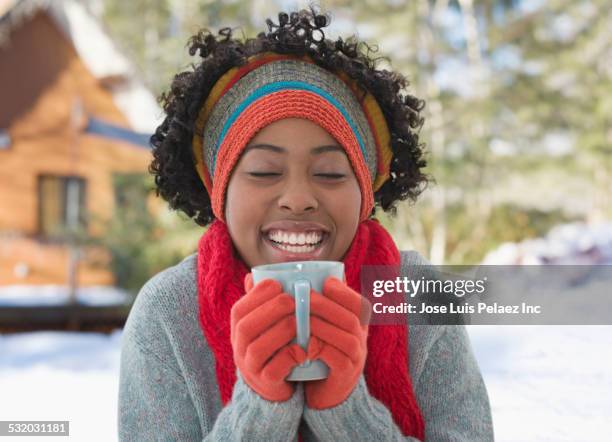 african american woman drinking cup of coffee in winter - adult woman cup tea stockfoto's en -beelden