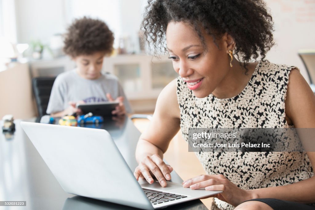 Mixed race businesswoman working at home