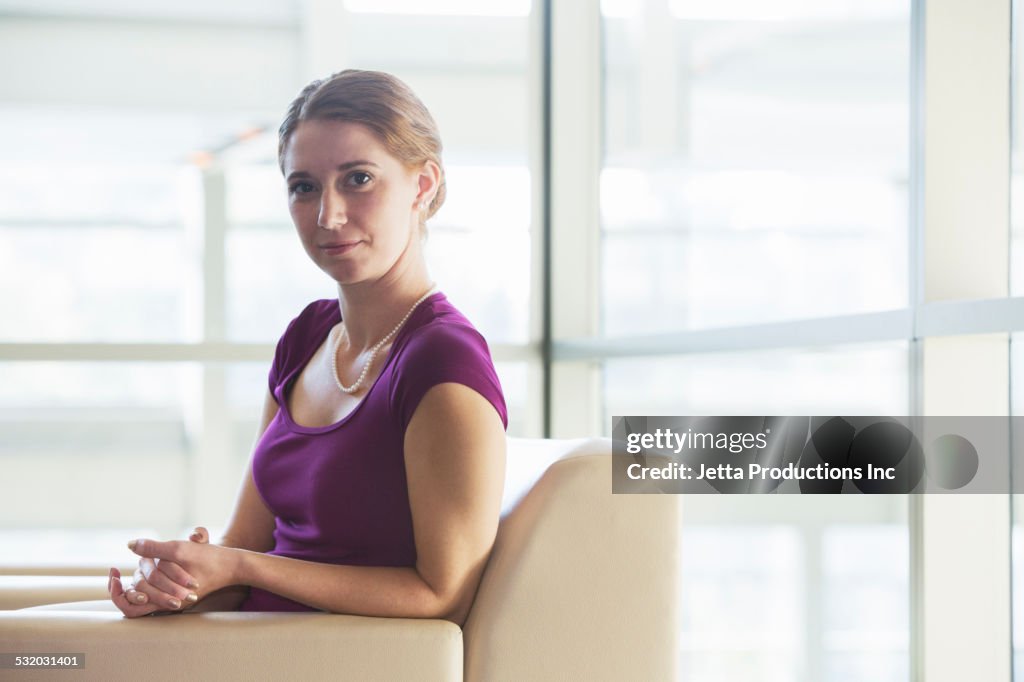 Caucasian businesswoman sitting in office lobby