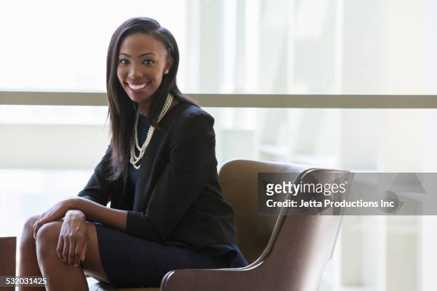 african american businesswoman sitting in office - leanincollection stock pictures, royalty-free photos & images