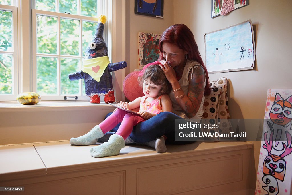 Caucasian mother and daughter using digital tablet