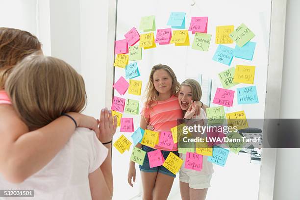 caucasian girls admiring themselves in mirror with adhesive notes - girls playing with themselves bildbanksfoton och bilder