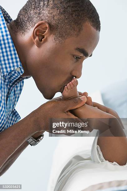 father kissing feet of baby son - foot kiss stock pictures, royalty-free photos & images