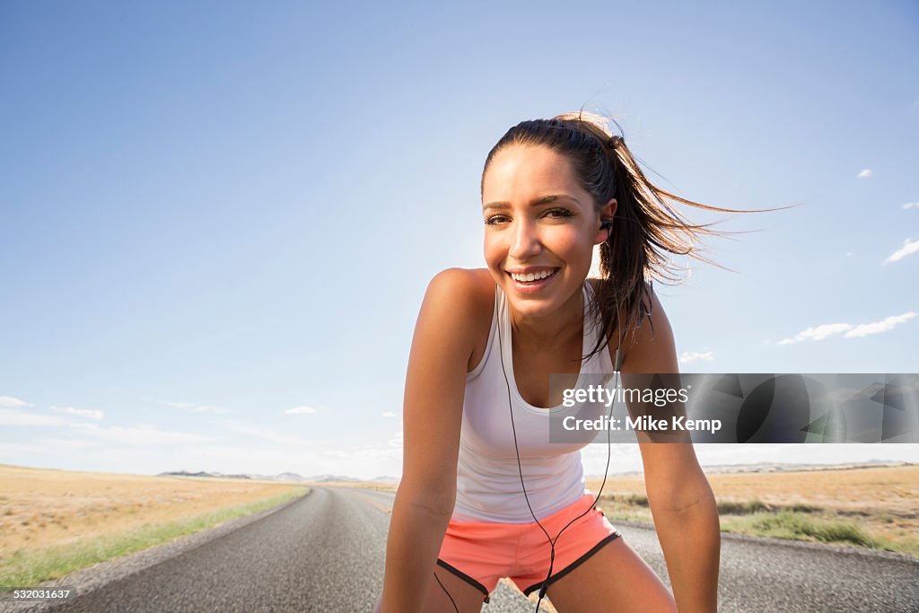 Caucasian runner resting on remoter road