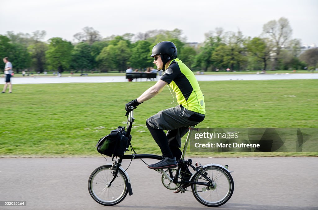 Man on foldable bicycle passing by
