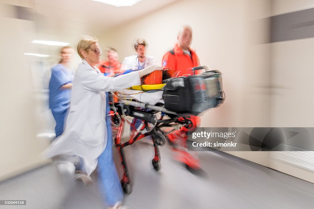 Paramedics wheeling patient in hospital