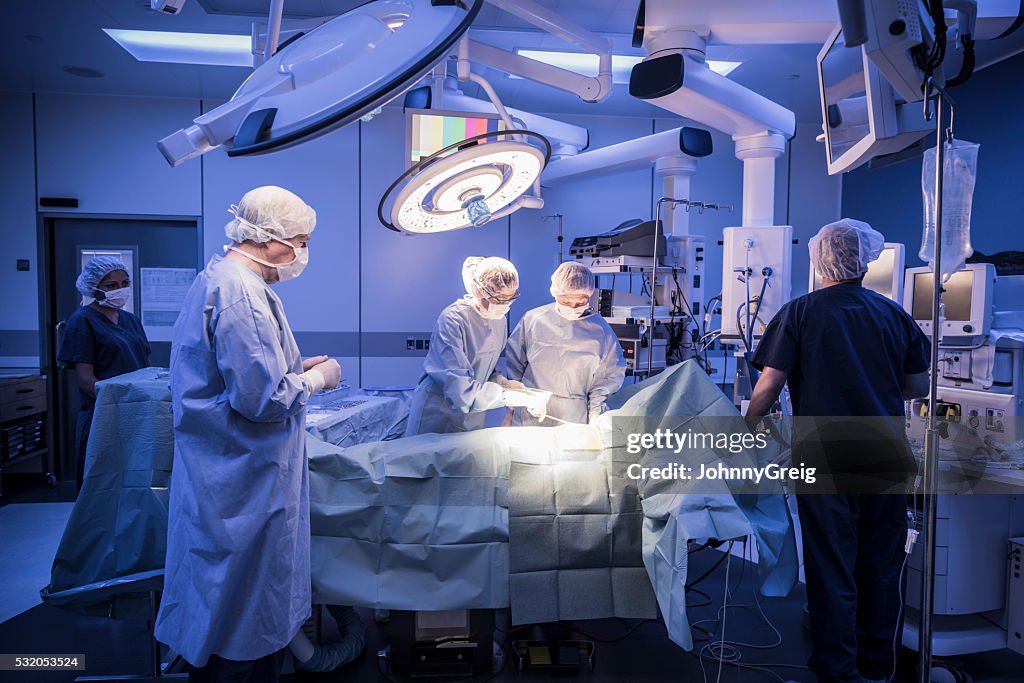 Team of surgeons operating on patient in hospital