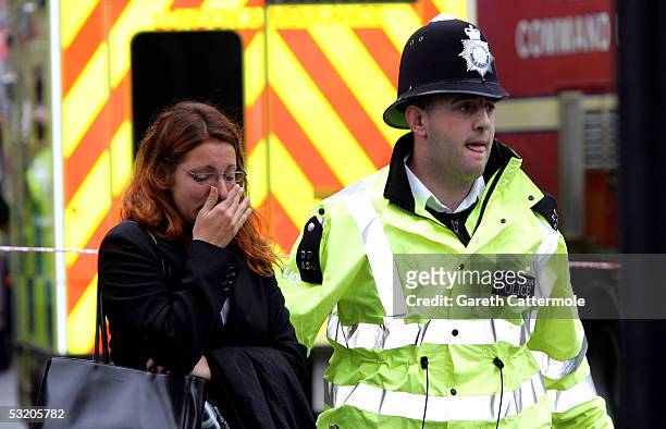 Police officer assists a woman at Edgware Road following an explosion which has ripped through London's inderground tube network on July 7, 2005 in...