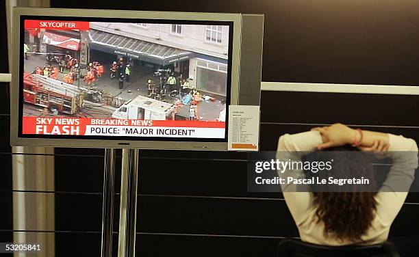 Journalist watches breaking news on the bombings in central London on a TV screen in the Press work arena in Gleneagles July 7, 2005. Apart from the...