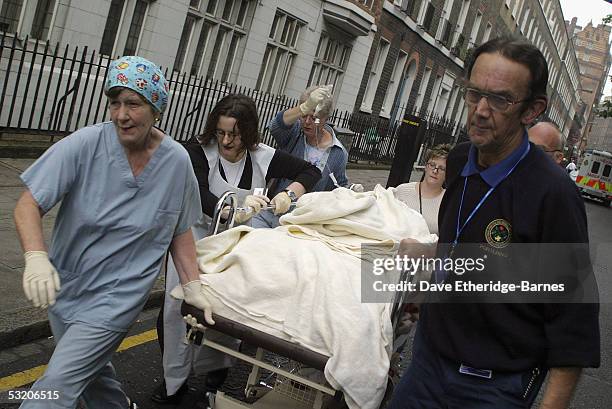 Medical staff stretcher a victim away from Russell Square underground station after a series of explosions ripped through London's transport network...