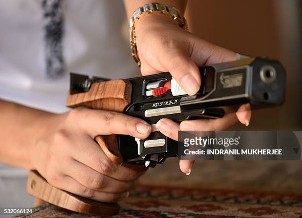 Shooting', INTERVIEW by Peter HUTCHISON In this photograph taken on April 25 Indian shooter Heena Sidhu prepares a pistol before taking part in a...