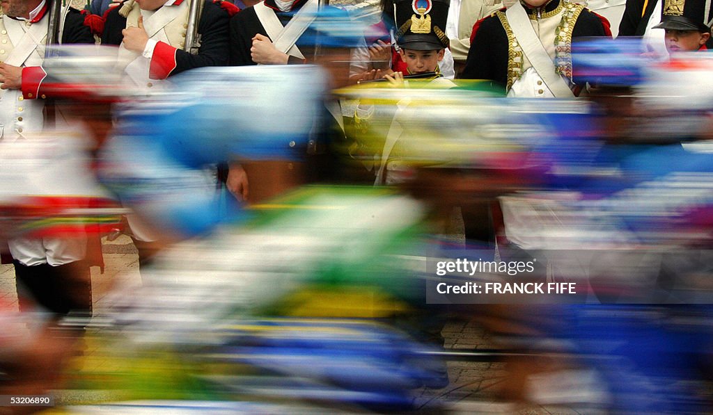 Cyclists ride past a fanfare during the