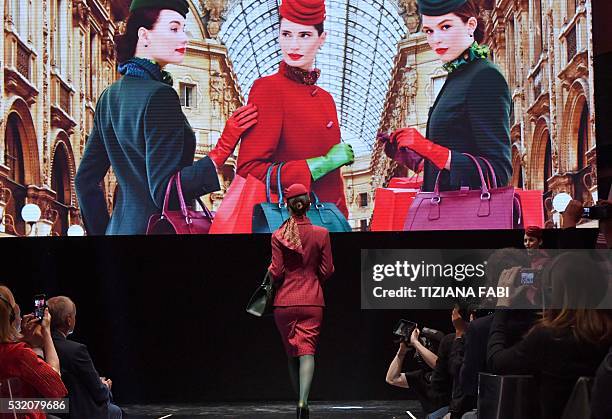 Model presents a new uniform for hostesses of Italian airline Alitalia, during a press conference on May 18, 2016 in Rome. / AFP / TIZIANA FABI