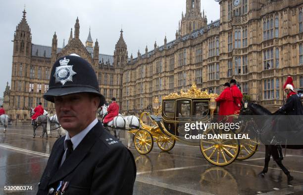 Policeman stands guard as Britain's Queen Elizabeth II and Prince Phillip leave the Houses of Parliament in the Jubilee State Coach in London on May...