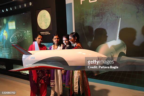 Group of young women look at a model of India’s first re-usable Launch Vehicle or 'Space Shuttle' at Vikram Sarabhai Space Center on March 30, 2016...