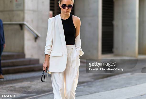 Guest wearing a white suit and black tank top and round sunglasses outside C Meo Collective at Mercedes-Benz Fashion Week Resort 17 Collections at...