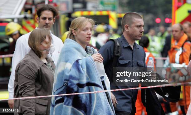 Shocked commuters with blackened faces walk away from Edgware Road underground station after bomb blasts ripped across London's underground network...