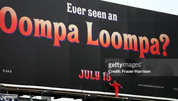 Actor Deep Roy who plays an Oompa Loompa in "Charlie and the Chocolate Factory" dances on the movie billboard ahead of the upcoming July 15 movie...
