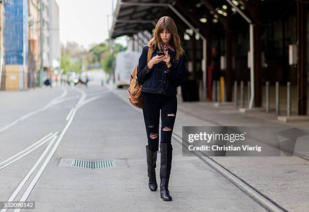 Model wearing a black denim jacket ripped jeans and black boots outside Emma Mulholland at Mercedes-Benz Fashion Week Resort 17 Collections at...
