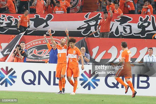 Diego Tardelli of Shandong Luneng celebrates with team mates after scoring the equalizing goal during the AFC Champions League Round of 16 First Leg...