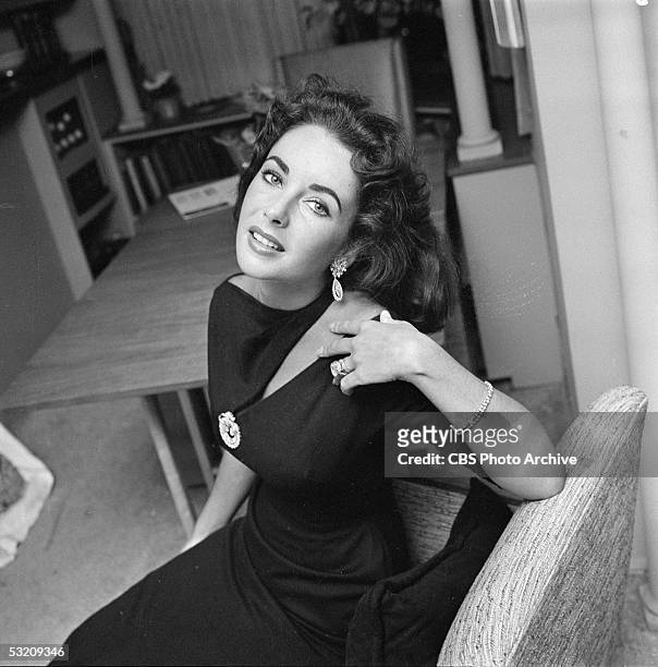 British-born actress Elizabeth Taylor poses, with her head thrown back, in her home, Berverly Hills, California, February 20, 1957. She is wearing a...