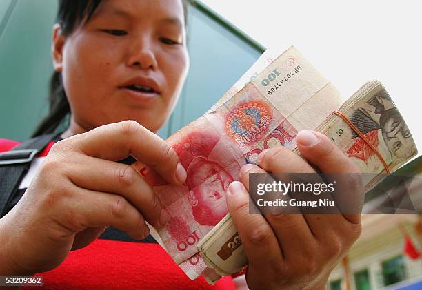 Chinese female money changer counts Chinese and Laotian money near the Mohan port border between China and Laos and the end point of the Chinese...