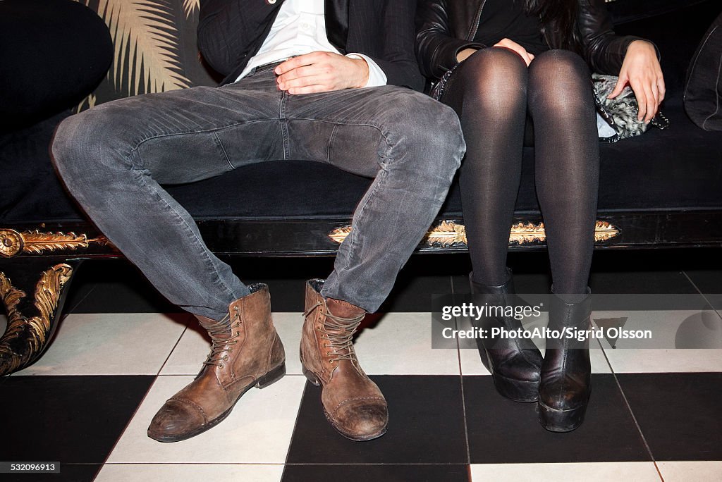 Young couple sitting side by side at night club