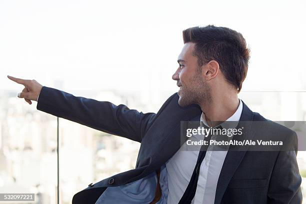 businessman on rooftop, pointing at view - buenos aires rooftop stockfoto's en -beelden