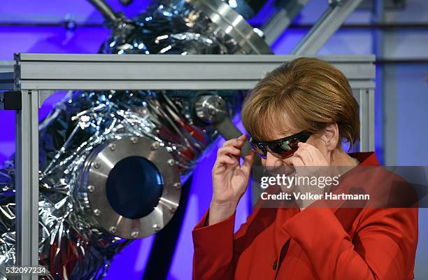 German Chancellor Angela Merkel wears safety goggles while watching an experiment in the DLR_School_Lab Koln during a visit of the European...