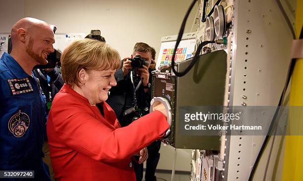 German Chancellor Angela Merkel is watched by German astronaut Alexander Gerst in the BIOLAB Training Facility during a visit of the European...