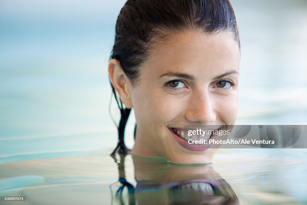 Woman relaxing in swimming pool, portrait