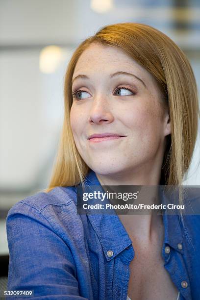 young woman giving knowing look - sourire narquois photos et images de collection