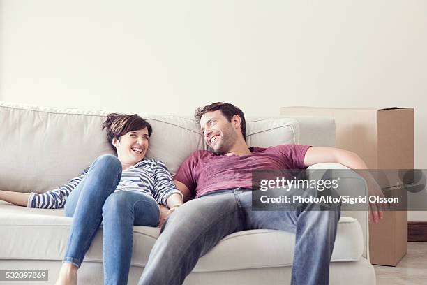 couple relaxing on sofa while moving house - newly married stock pictures, royalty-free photos & images