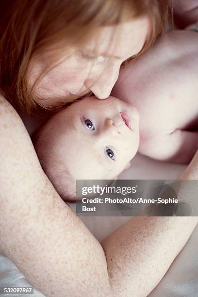 mother nuzzling baby, overhead view - red hair boy and freckles stock-fotos und bilder