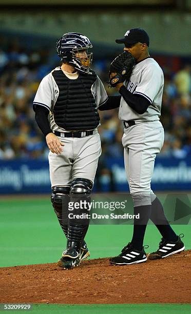 Catcher John Flaherty of the New York Yankees talks to his pitcher Orlando Hernandez during the game against the Toronto Blue Jays at the Skydome on...