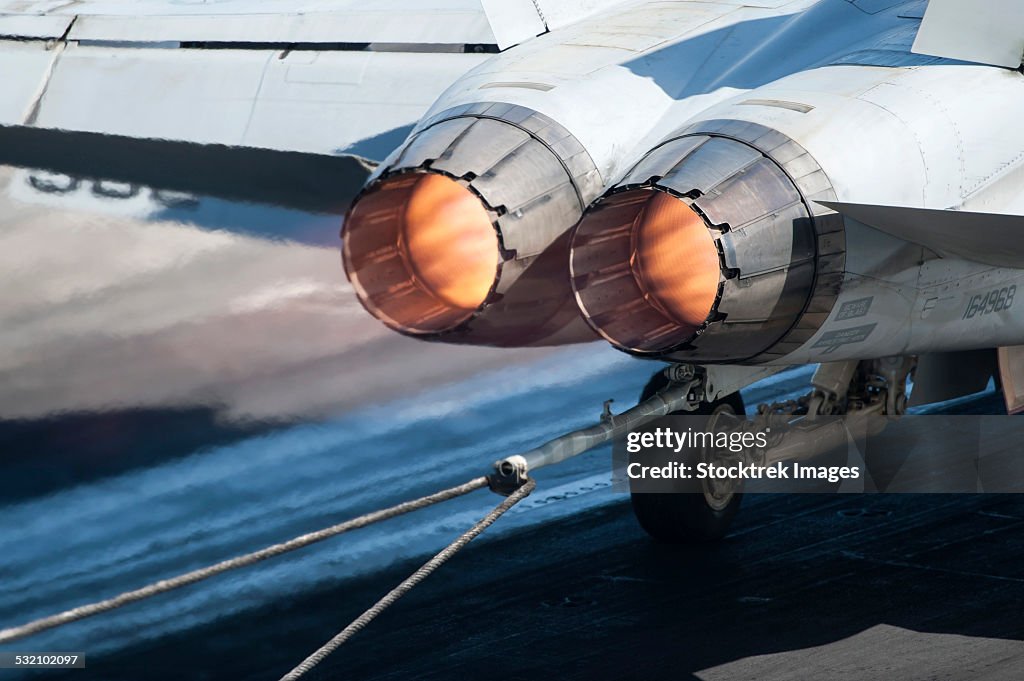 An F/A-18C Hornet catches an arresting gear wire.