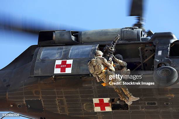 royal australian air force aircraftman is hoisted onto a uh-60 black hawk. - operation enduring freedom stock pictures, royalty-free photos & images