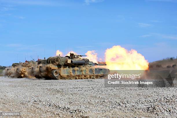 m1a1 abrams fire their 120mm smoothbore cannon. - m1 abrams stock pictures, royalty-free photos & images