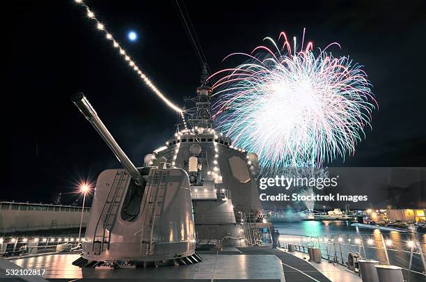 fireworks light up the sky behind the guided missile destroyer js kirishima. - hawaii missile stock pictures, royalty-free photos & images