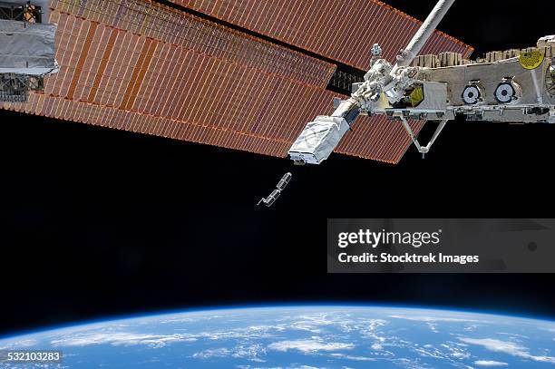 the small satellite orbital deployer in the grasp of a robotic arm. - cubesat photos et images de collection