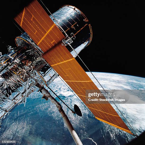 april 25, 1990 - the hubble space telescope backdropped by planet earth. - hubble space telescope stock pictures, royalty-free photos & images