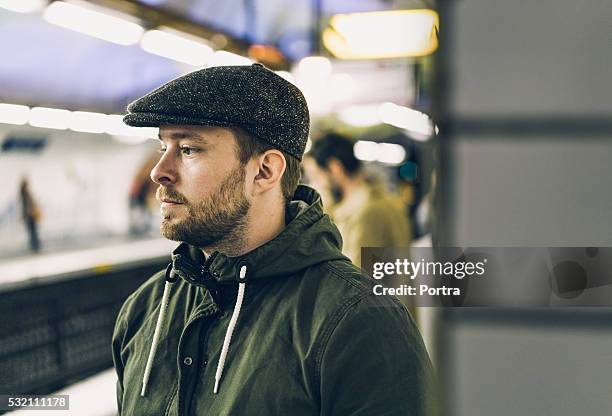 thoughtful man wearing cap at railroad station - flat cap 個照片及圖片檔