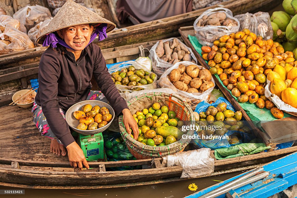 Vietnamese woman selling fruit on floating market, Mekong River Delta,