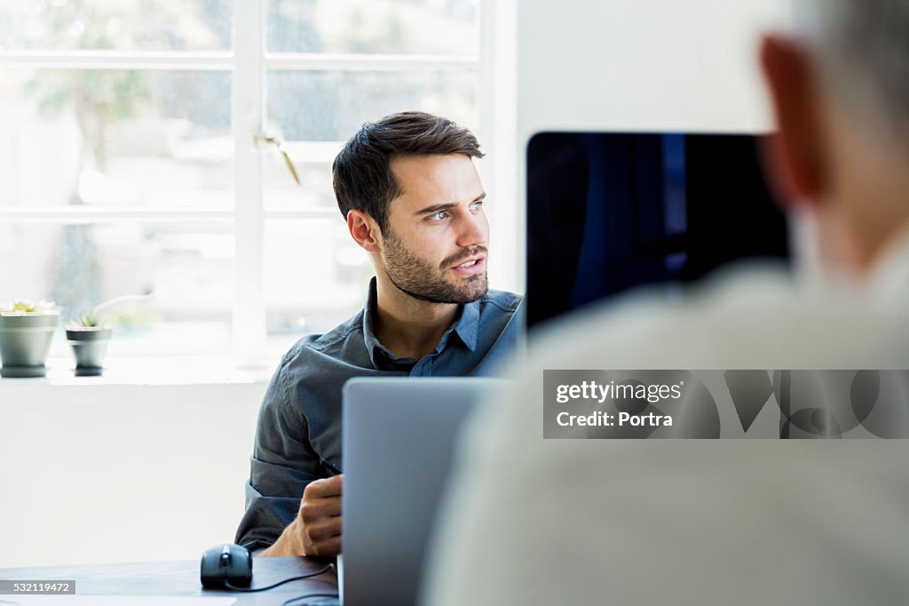 Thoughtful businessman looking away in office